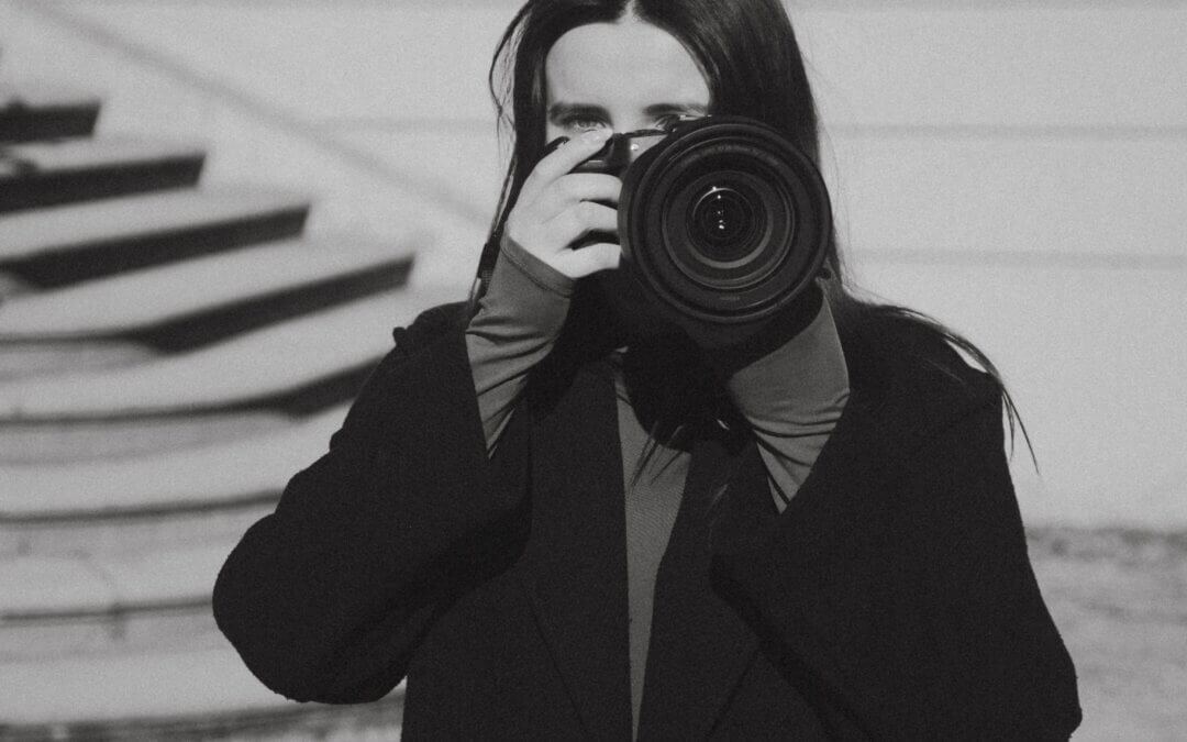 Fotografa con in mano la fotocamera, pronta a scattare