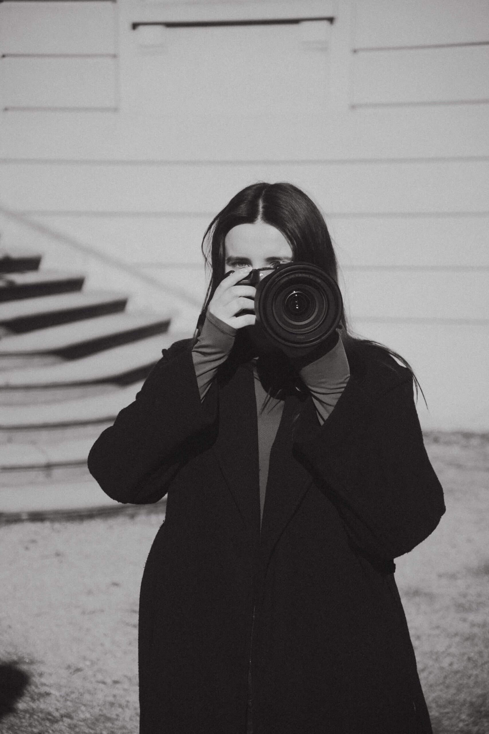 Fotografa con in mano la fotocamera, pronta a scattare